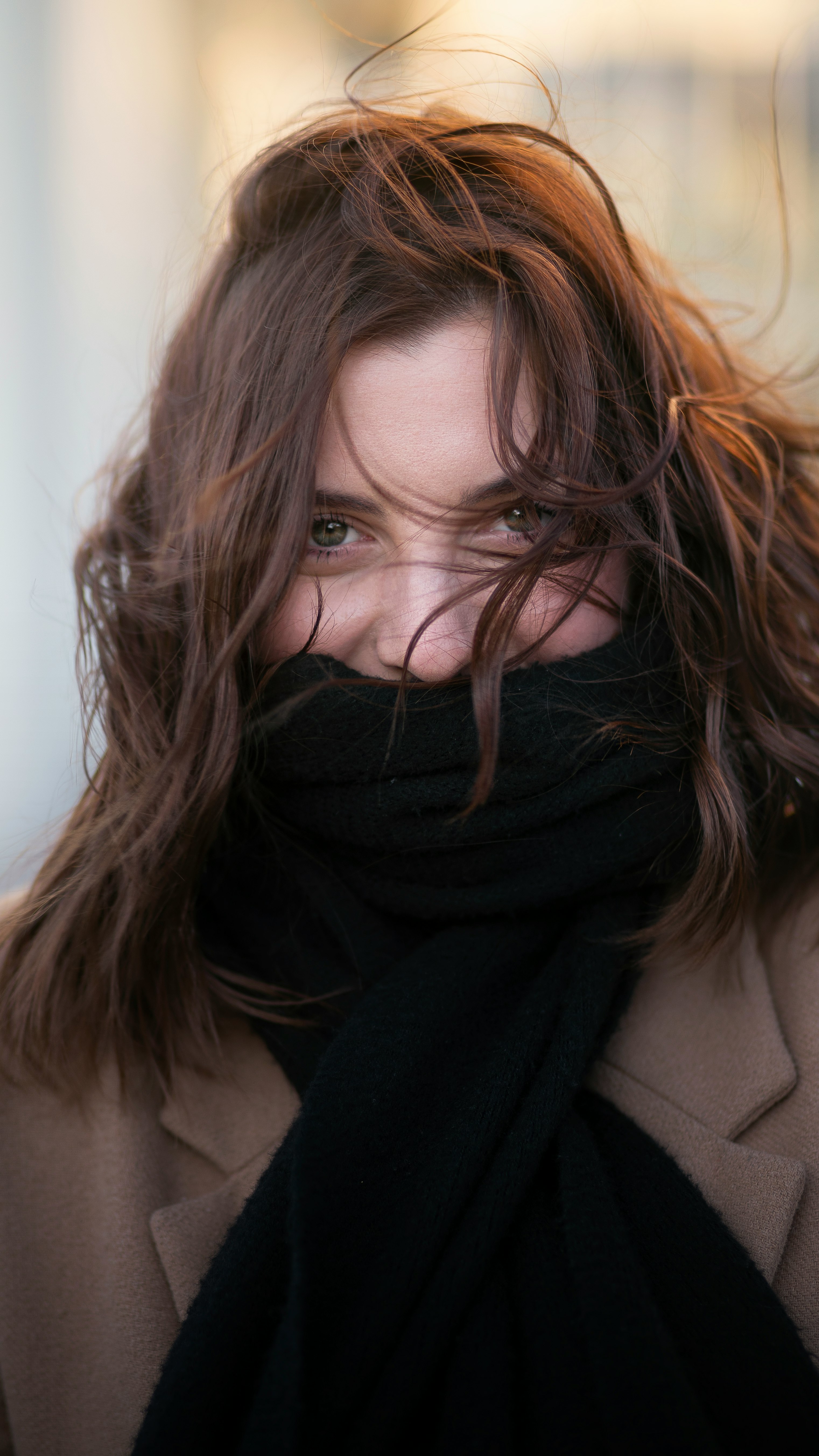 woman smiling and looking at the camera with scarf covering her mouth